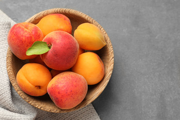 Bowl with ripe sweet apricots on table