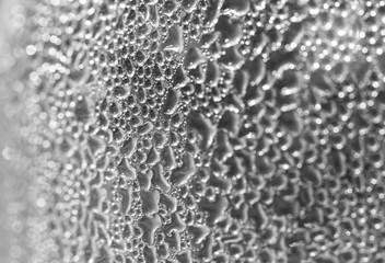 .Drops on the wall of the bottle, condensation of water on the bottle. Bottle took out of the fridge and formed a sweat. Blurred background.