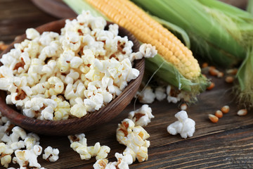 Bowl with delicious popcorn on wooden background
