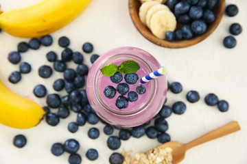 Glass jar with tasty blueberry smoothie on table, top view