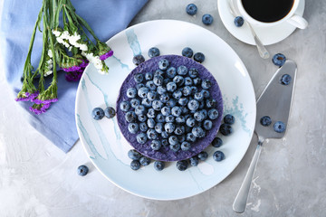 Plate with delicious blueberry cheesecake on table