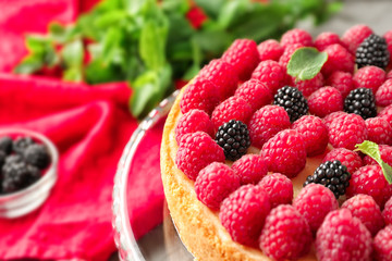Delicious cheesecake with raspberries on stand, closeup