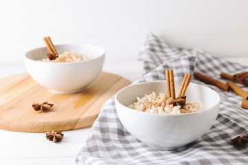 Bowls with delicious rice pudding and cinnamon powder on table