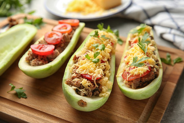 Meat stuffed zucchini boats on board, closeup