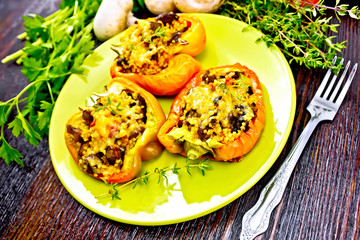 Pepper stuffed with mushrooms and couscous in green plate on boa