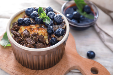 Bowl with delicious blueberry pudding on board, closeup