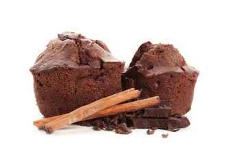 Sweet tasty muffins with cinnamon sticks and chocolate on white background