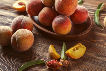 Plate with fresh peaches on wooden table, closeup