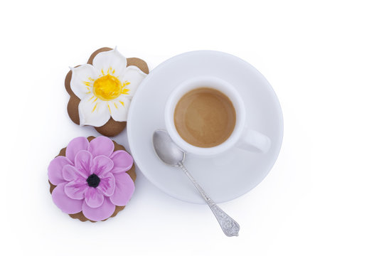 Flower shaped gingerbread cookies and cup of coffee with spoon on white background