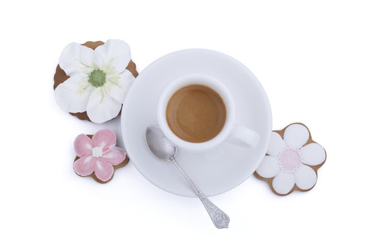 Flower shaped gingerbread cookies and cup of coffee with spoon on white background