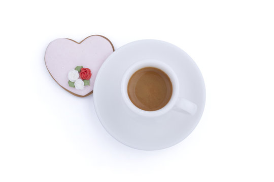 Heart shaped gingerbread cookie and cup of coffee on white background