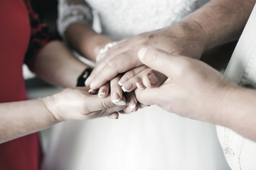 Closeup of a stack of hands. People, putting their hands on each other, symbolize unity, love and teamwork.