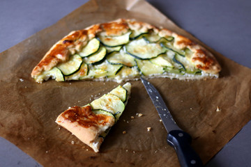 Galette made with courgette and cheese (ricotta, mozzarella, parmesan). Top view, selective focus.
