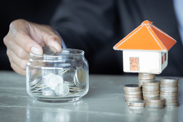 Savings money jar of coins concept for saving or investment for a house.