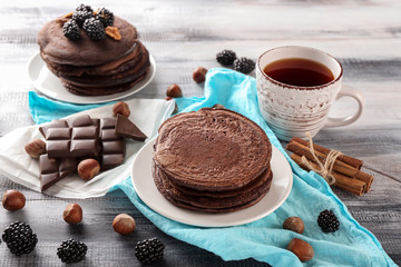 Composition with tasty chocolate pancakes on wooden table
