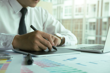 Close up hands male graphic designers,interior designer.Working on graphic tablet in modern space office.discuss data about new start up project of graphics design style and graphics design diagram