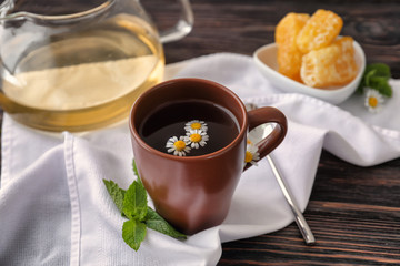 Cup of delicious camomile tea on wooden table