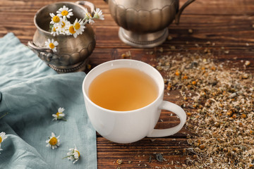 Obraz na płótnie Canvas Cup of delicious camomile tea on wooden table