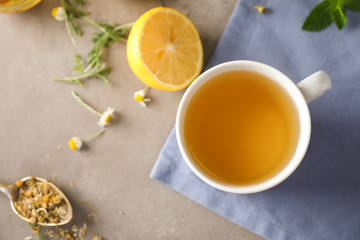 Obraz na płótnie Canvas Cup of delicious camomile tea on light table