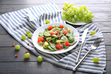 Plate with healthy fresh salad on wooden table