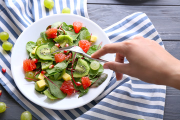 Woman eating healthy fresh salad, closeup