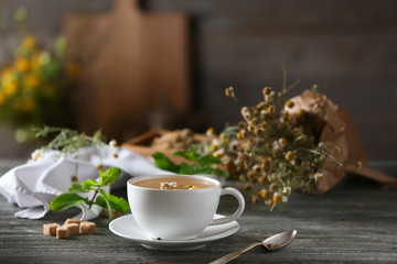 Cup of delicious chamomile tea on wooden table
