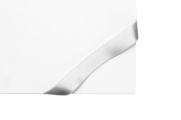 Silver ribbon with sheet of paper isolated on white