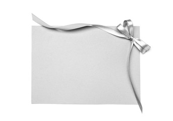 Blank paper card with silver ribbon and bow on white background
