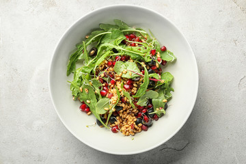 Bowl with healthy fresh salad on light background