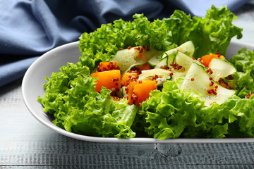 Plate with healthy fresh salad on wooden table