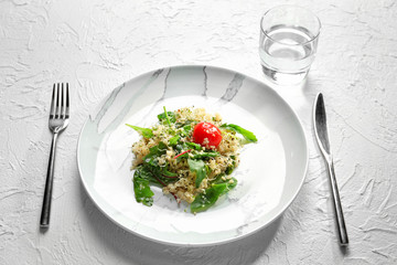 Plate with healthy fresh salad on light background