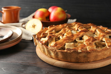 Board with delicious apple pie on wooden table