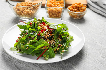 Plate with healthy fresh salad on white wooden table