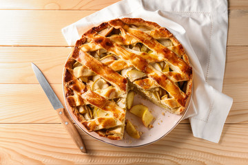 Plate with delicious apple pie on wooden table