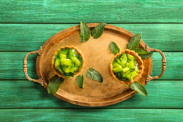Delicious tarts with kiwi on metal tray