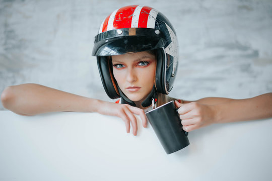 Female biker girl with black full face motorcycle helmet.Copy space for advertising biker products. Extreme lifestyle concept. Sexy girls in formula one style