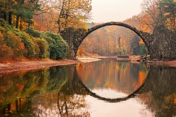 Foto auf Acrylglas Rakotzbrücke Rakotzbrücke (Rakotzbrucke, Teufelsbrücke) in Kromlau, Sachsen, Deutschland. Farbenfroher Herbst, Spiegelung der Brücke im Wasser bilden einen Kreis. Ungewöhnliche und interessante Orte in Deutschland.