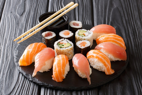 Japanese sushi on a rustic dark background. Sushi rolls, nigiri, maki, soy sauce. Sushi set on a table. background. Asian food. Horizontal