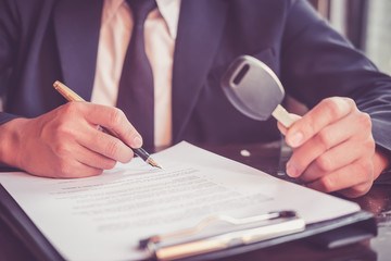 real estate agent holding key car to his client after signing contract,concept insurance with car,...