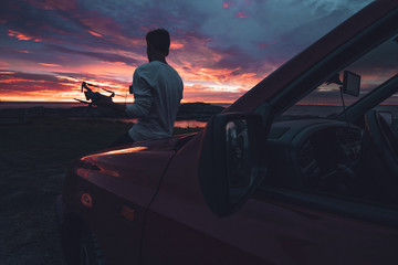 a drone pilot carrying his drone while sunset © SmallWorldProduction