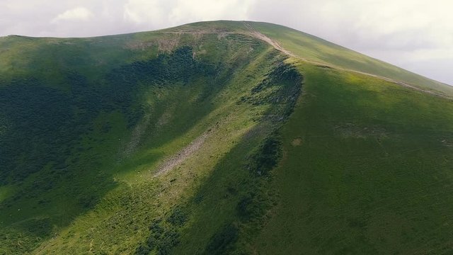 Aerial shot of a Carpathian peak with a concave hollow in summer