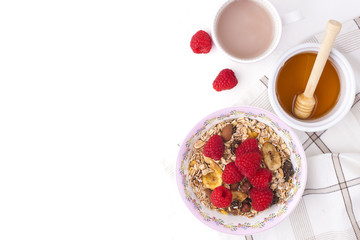 Delicious and healthy breakfast on a white background. Porridge of oatmeal, raspberry, honey, coffee for a good morning. Free space for text, top view