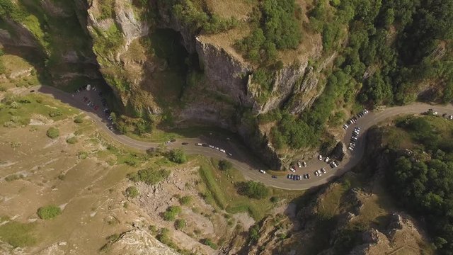Cars driving on winding scenic road in beautiful valley, aerial drone shot