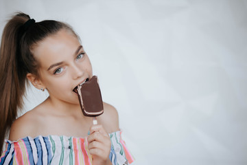 Happy girl eating ice cream. Young hipster girl eating a delicious ice cream in summer hot weathe. Chocolate. Cream. Ice. Sweet Tooth