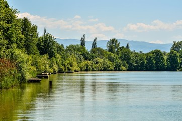 Daily springtime landscape. Beautiful lake with mountains in the background.