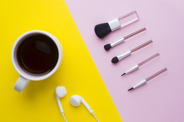 Makeup brushes on a pastel pink background and a Cup of coffee on a yellow background. Beauty concept