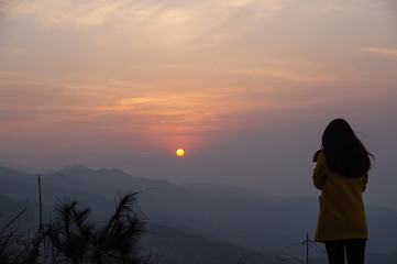 Back View of A Chinese Standing on the Mountain Watching the Sunrise
