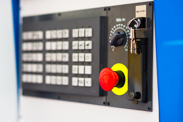 Red button on control panel of a factory machine