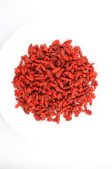 dried goji berries on a white plate food background texture with copy space