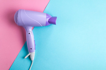 Hairdryer on a bright, colored background. Hairdressing Supplies. Beauty saloon. Fashion concept. Top view. Copy space
